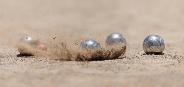 Petanque top bulvarları toz zeminde kaseler, çarpma anında fotoğraf. Toplar ve küçük bir tahta kriko.