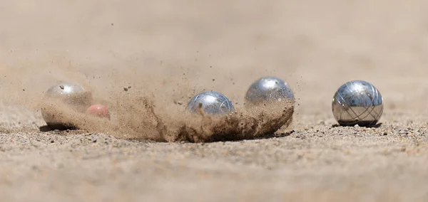 Petanque top bulvarları toz zeminde kaseler, çarpma anında fotoğraf. Toplar ve küçük bir tahta kriko.