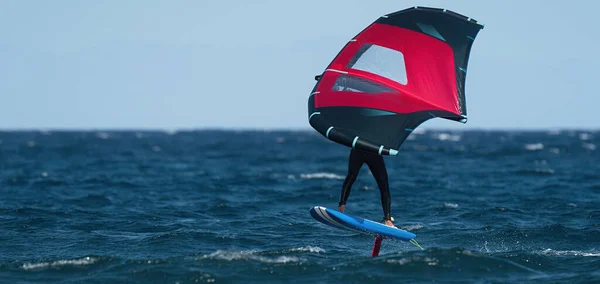 Man Wing Foiling Using Handheld Inflatable Wings Hydrofoil Surfboards Blue — Stock Photo, Image