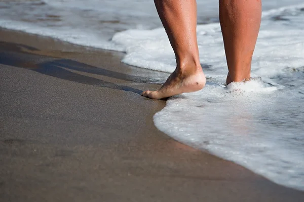 Mulher andando descalça na praia ensolarada — Fotografia de Stock