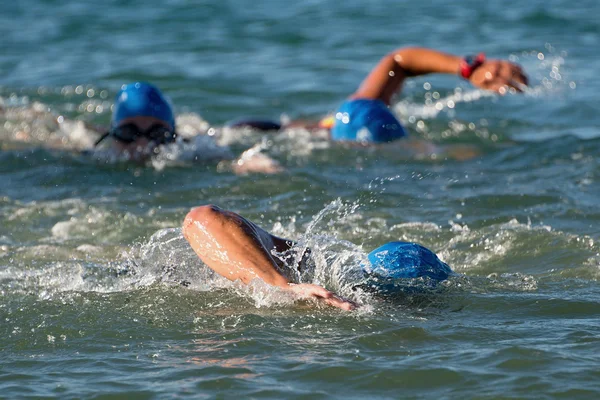 Les participants au triathlon courent dans l'eau pour la partie nage de la course — Photo