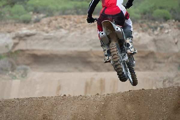 Motorcrosser versnellen in dirt track — Stockfoto