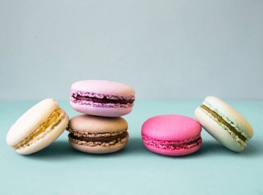 Mavi arkaplan yatay yöneliminde renkli badem kurabiyesi ya da badem kurabiyesi