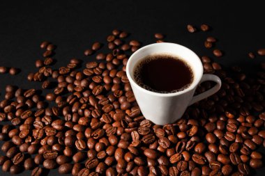 Siyah arkaplanda kahve çekirdekleri olan Espresso kahve fincanları. Yatay yönelim.