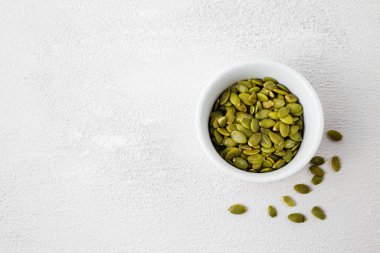 Beyaz kasede kavrulmuş balkabağı tohumlarının üst görüntüsü. Beyaz arka plan bombardımanından sonra Pepita 'yı kurut. Uzayı kopyala Yatay