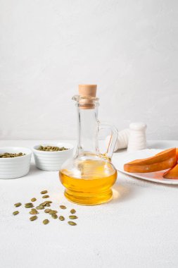 Beyaz arka planda balkabağı tohumu yağı var. Uzayın dikey bileşimini kopyala. Pepita..