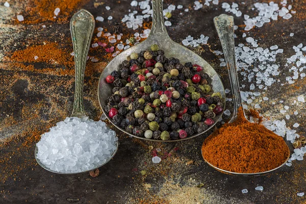 Peppercorny, Křišťálová sůl a paprikou na rustikálním pozadí-zaostřená — Stock fotografie