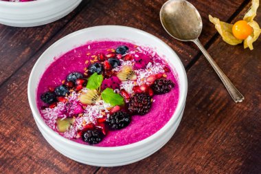 Meyveli, hindistan cevizli ve keten tohumlu pembe pitaya smoothie kasesi. Sağlıklı kahvaltı fikri..