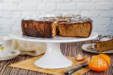 Baharatlı portakal ve badem keki krema şekeri ve bal serpilmiş.
