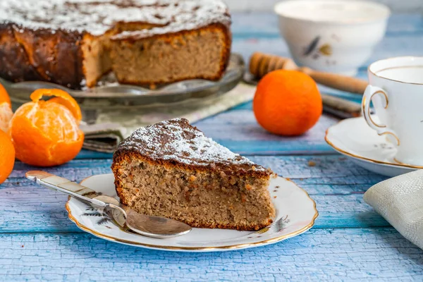 Spiced orange and almond cake dusted with icing sugar and drizzled with honey