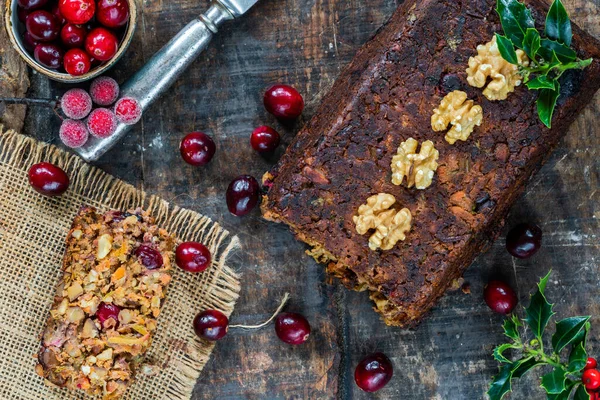 Vegan roasted nut loaf with cranberries on wooden table - overhead view