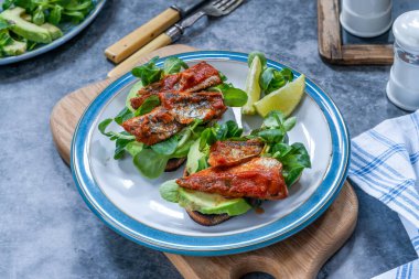 Domates soslu sardalya, avokado ve kuzu salatalı tost.