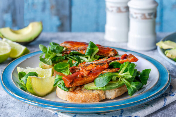 Сардины в томатном соусе с авокадо и салатом из ягнят на тосте