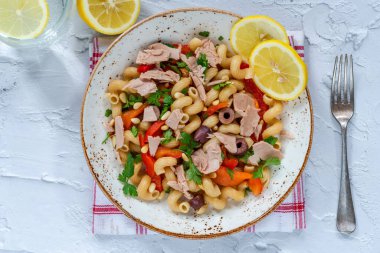 Warm pasta salad with tuna, roasted red pepper and pine nuts - overhead view clipart
