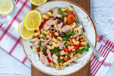 Warm pasta salad with tuna, roasted red pepper and pine nuts - overhead view clipart