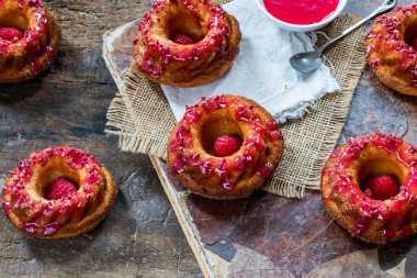 Ahududu kremalı mini vanilyalı kekler. Yüksek açılı.