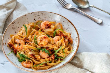 Domatesli kaplan karidesi, acılı biber ve fettucine makarna ile badem pesto.