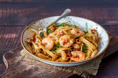 Domatesli kaplan karidesi, acılı biber ve fettucine makarna ile badem pesto.