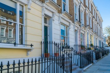 LONDON, İngiltere - 29 Mart 2021: Londra 'nın Primrose Hill kentsel alanındaki Chalcot Yolu üzerinde parlak renkli teraslı evler. Bu alan genellikle filmler ve televizyonlarda kullanılır..