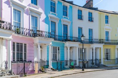 LONDON, İngiltere - 29 Mart 2021: Londra 'nın Primrose Hill kentsel alanındaki Chalcot Crescent' te parlak renkli teraslı evler. Bu alan genellikle filmler ve televizyonlarda kullanılır..