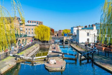 LONDON, İngiltere - 29 Mart 2021: İnsanlar Camden Lock 'ta güneşli havanın keyfini çıkarıyor Londra' daki Camden Town Regent Kanalı 'nın kıyısında
