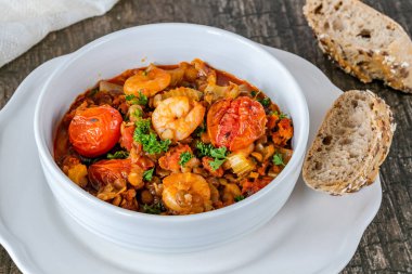 Chorizo, mercimek ve kavrulmuş domatesli karides güveci.