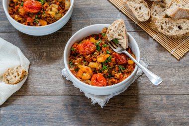 Chorizo, mercimek ve kavrulmuş domatesli karides güveci.