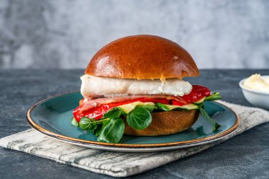 Pastırmalı ızgara halibut sandviçi, kırmızı Romano biberi, kabak ve kuzu marulu.