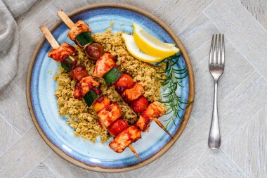 Spicy chicken, tomato and courgette skewers with couscous - overhead view