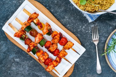 Spicy chicken, tomato and courgette skewers with couscous - overhead view