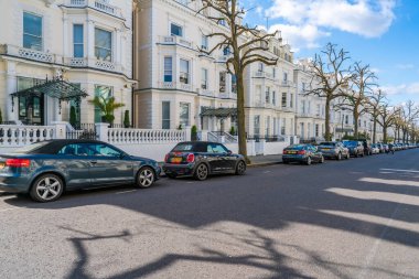 LONDON, İngiltere - 11 Nisan 2021: geniş Viktorya dönemi konutları olan Holland Park 'ın yerleşim alanı. Batı Londra 'nın bu varlıklı bölgesi başkentteki en pahalı mülklere sahiptir.