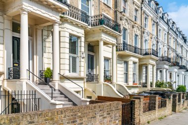 LONDON, UK - APRIL 21, 2021: Residential street in Mailda Vale in London. This affluent neighbourhood has many large late Victorian and Edwardian blocks of mansion flats and wide, quiet roads.  clipart