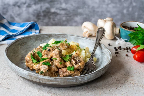 Beef goulash with creamy mushroom and black peppercorn sauce and crushed boiled potatoes