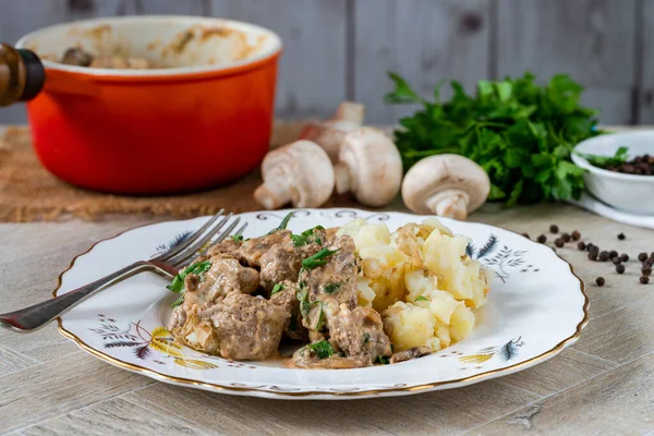 Beef goulash with creamy mushroom and black peppercorn sauce and crushed boiled potatoes