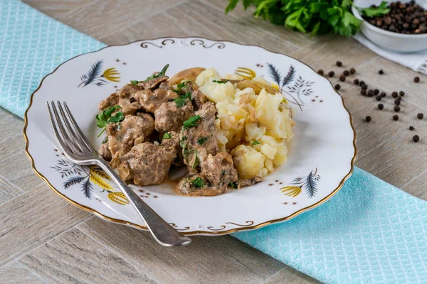 Beef goulash with creamy mushroom and black peppercorn sauce and crushed boiled potatoes