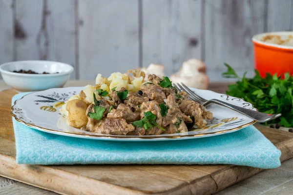 Beef goulash with creamy mushroom and black peppercorn sauce and crushed boiled potatoes