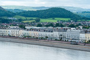 LLANDUDNO, WALES - 3 Temmuz 2021: otellerin oluşturduğu Llandudno kıvrımlı gezinti alanı. Llandudno, Galler 'in en büyük sahil beldesidir..