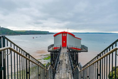 Güney Pembrokeshire, Galler 'de Tenby sahilinde ahşap bir iskele ve bir filika istasyonu.