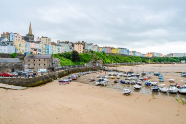TENBY, WALES - 28 Haziran 2021: Tenby limanındaki renkli evler, Galler 'in Pembrokeshire şehrinde, Carmarthen Körfezi' nin batı yakasındaki bir sahil kasabası.