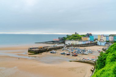 TENBY, WALES - 28 Haziran 2021: Tenby limanındaki renkli evler, Galler 'in Pembrokeshire şehrinde, Carmarthen Körfezi' nin batı yakasındaki bir sahil kasabası. 