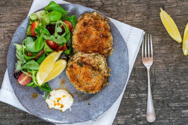 Yeşil yaprak salatası, sarımsaklı mayonez ve limonlu balık köftesi.