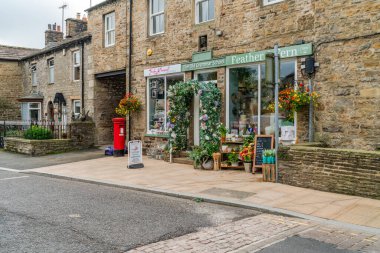 HAWES, UK - 23 Ağustos 2021: Hawes, Yorkshire Dales 'in göbeğinde, kaldırımlı caddelerle bağlantılı, taş binaları, dükkanları ve evleri olan bir pazar kasabasıdır. Wensleydale peynirinin büyük bir yapımcısı..