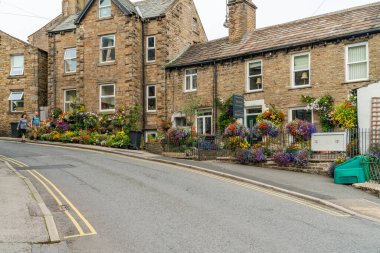 HAWES, UK - 23 Ağustos 2021: Hawes, Yorkshire Dales 'in göbeğinde, kaldırımlı caddelerle bağlantılı, taş binaları, dükkanları ve evleri olan bir pazar kasabasıdır. Wensleydale peynirinin büyük bir yapımcısı..