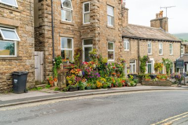 HAWES, UK - 23 Ağustos 2021: Hawes, Yorkshire Dales 'in göbeğinde, kaldırımlı caddelerle bağlantılı, taş binaları, dükkanları ve evleri olan bir pazar kasabasıdır. Wensleydale peynirinin büyük bir yapımcısı..