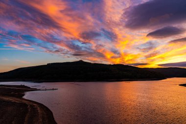 Yukarı Derwent Vadisi 'ndeki Ladybower Rezervuarı' nda Derbyshire, İngiltere 'de dramatik renkli bir gün batımı yaşanıyor.
