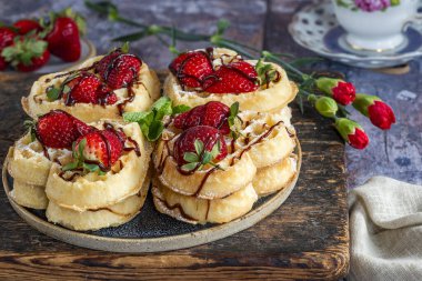 Kalp şeklinde Belçika waffle 'ları taze çilekle süslenmiş.