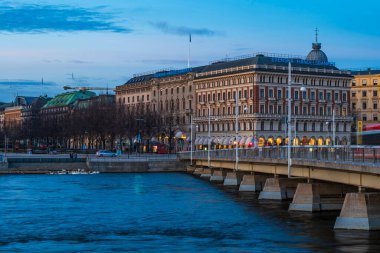 SVEDEN, STOCKHOLM - 08 Mart 2025: Stockholm 'ün merkezindeki Norrstrom' da Strandvagen setinin akşam manzarası. Strandvagen rıhtımda kafeler, restoranlar ve dükkanlarla dolu.