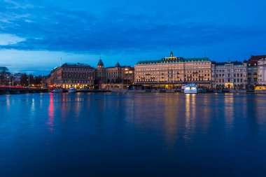 SVEDEN, STOCKHOLM - 08 Mart 2025: Stockholm 'ün merkezindeki Norrstrom' da Strandvagen setinin akşam manzarası. Strandvagen rıhtımda kafeler ve resimli teknelerle dolu.