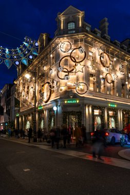 Londra, İngiltere - 30 Kasım 2025: Bu yıl Bond Caddesi Noel ışıkları, altın yıldız ve yüzüklerin sergilendiği Rolex mağazası ile parıltılı taç ve taç kemerlerinin sergilendiği bir yer.