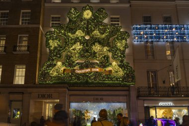 Londra, İngiltere - 30 Kasım 2025: New Bond Caddesi 'ndeki Dior mağazası Noel için dekore edilmiştir. Dior, Fransız çok uluslu lüks ürünler şirketidir. Dior Hanesi 1946 'da Paris' te kuruldu..
